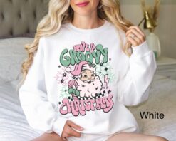 vintage christmas sweatshirt for women featuring retro santa design in pink for a groovy holiday look ja4wx
